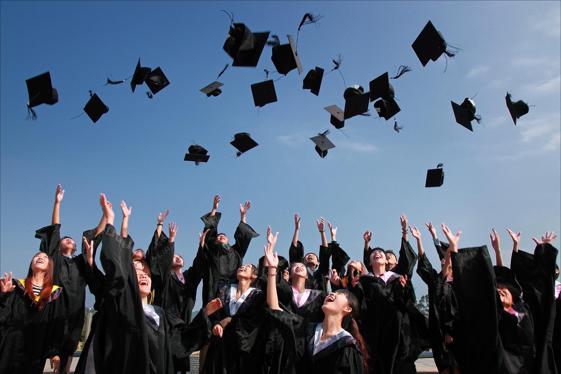 A graduating class throw their caps into the air at their graduation ceremony