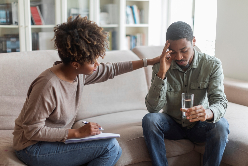 A female counselor helps a young man navigate through his grief.