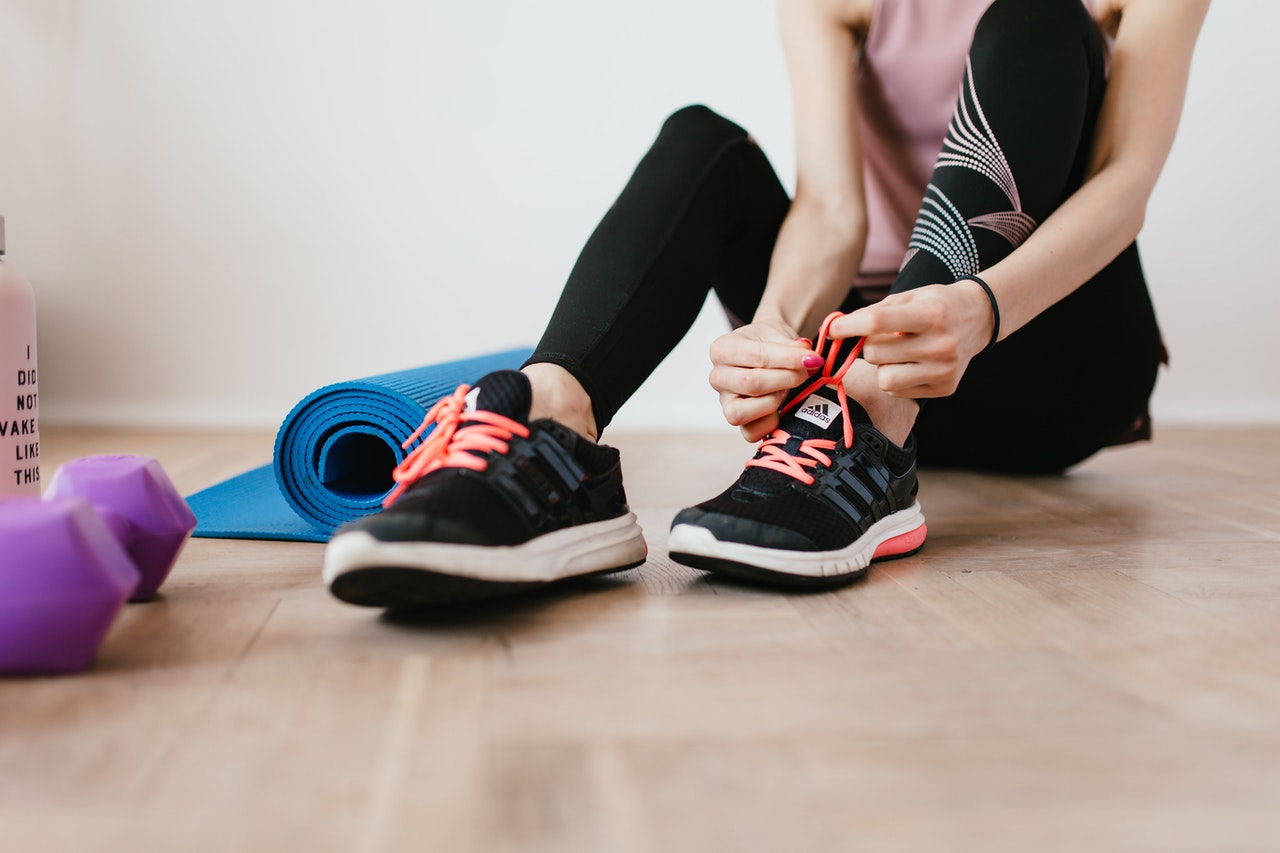 woman putting on athletic shoes