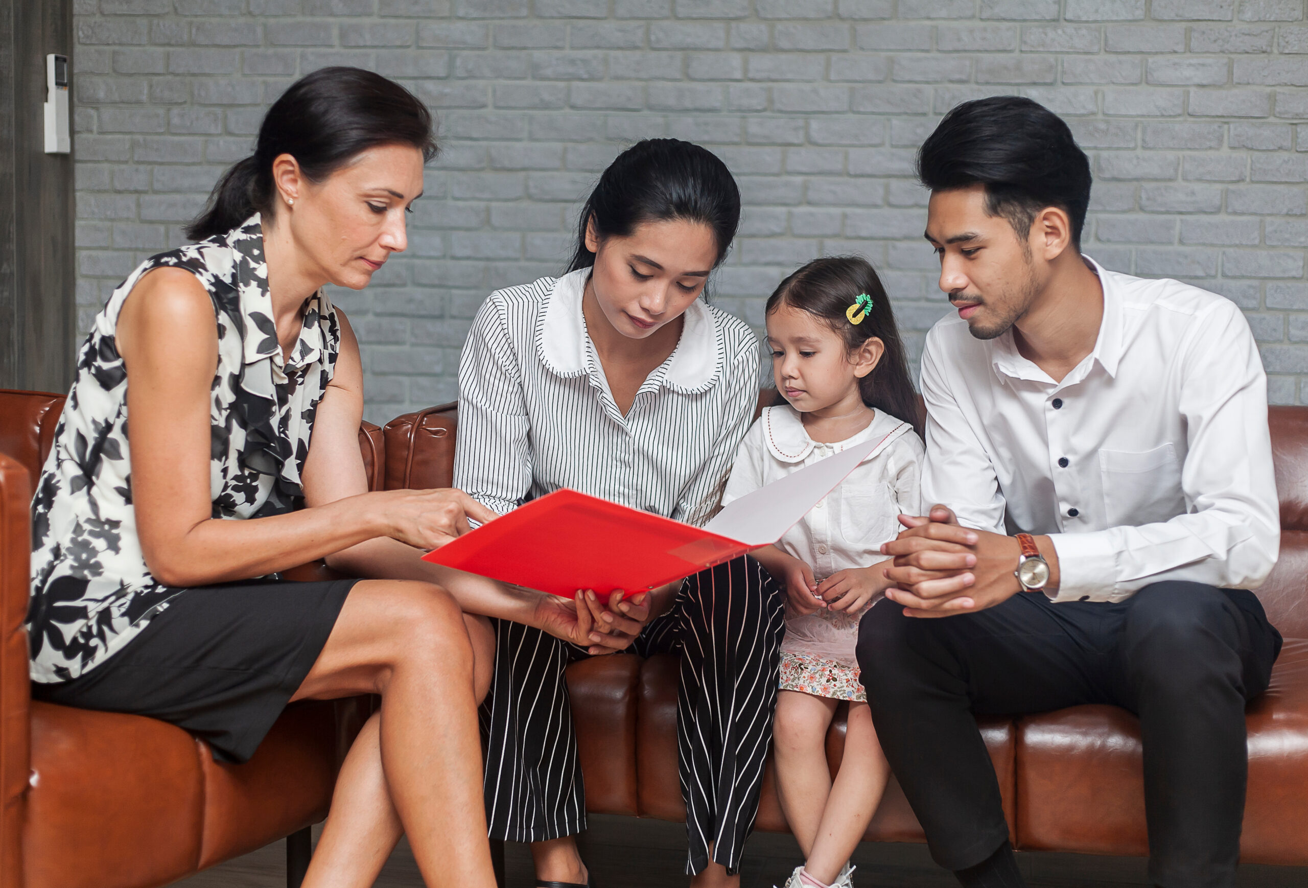 Asian Parent talking with teacher about Plan education for children. Young family and children discuss or advice with professional family psychologist in office