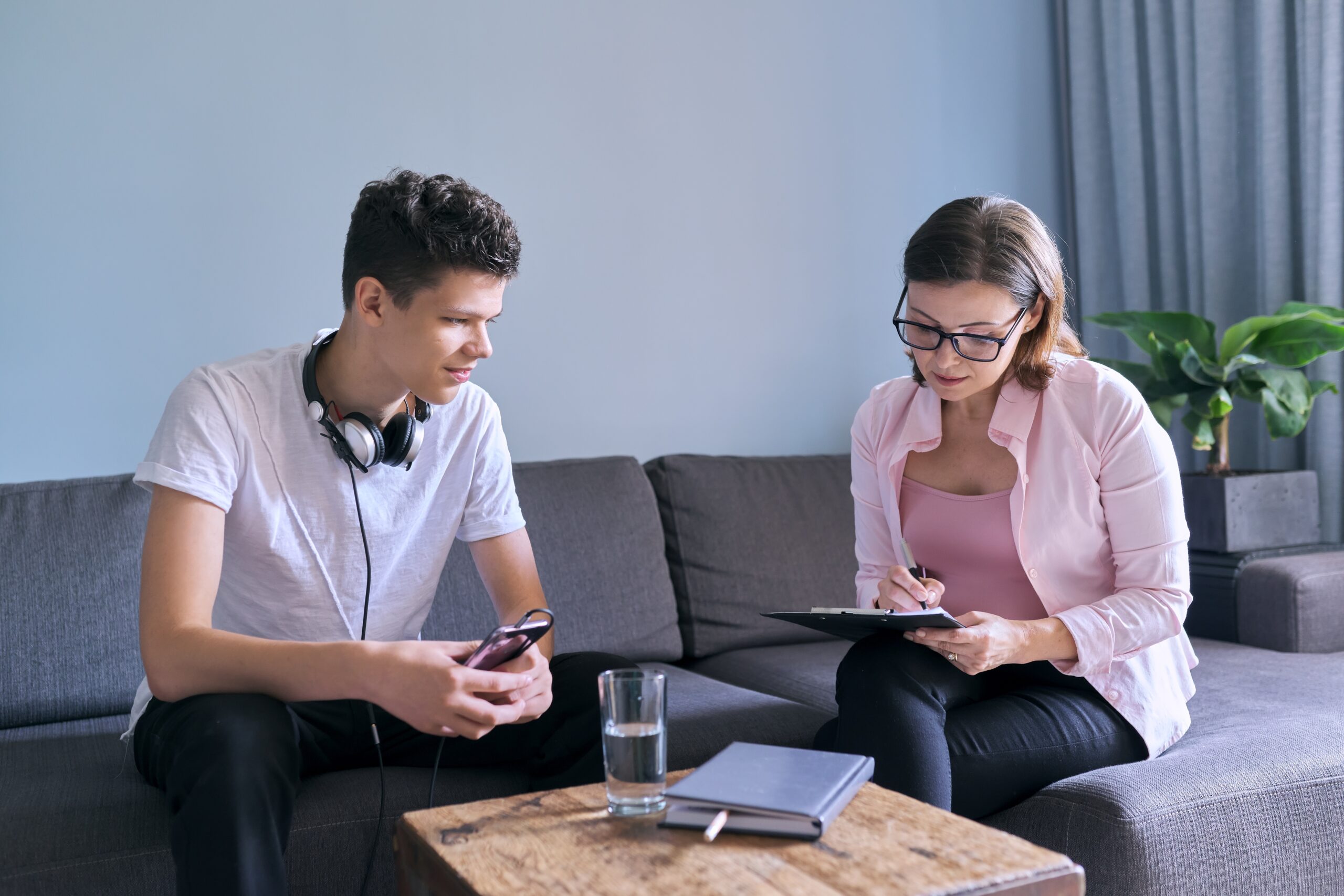 Teenage boy at meeting with female professional doctor psychologist