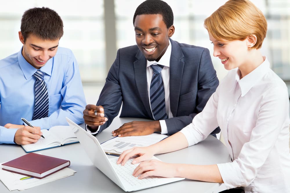 A smiling HR manager meets with his colleagues