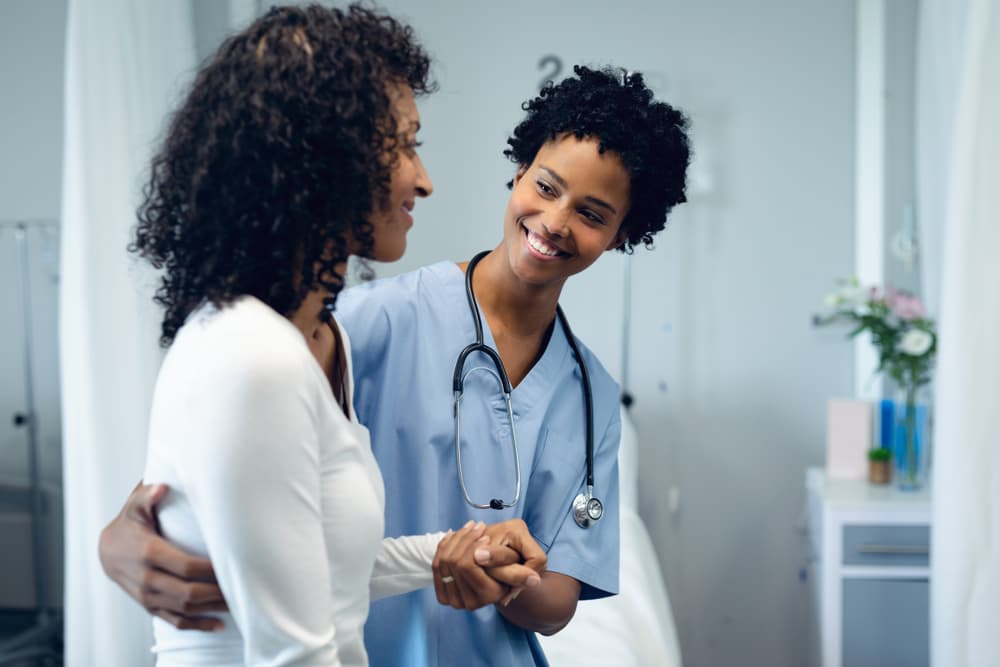 A smiling Physician Assistant tends to a patient.