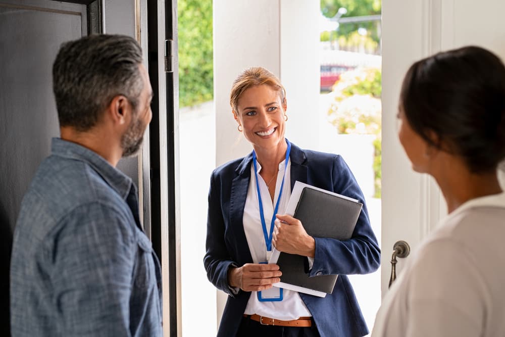 A female social worker arrives at the home of a middle-aged couple