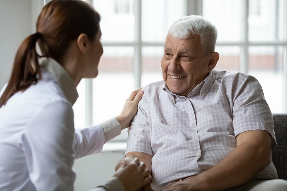 An in-home social worker comforts an elderly client.