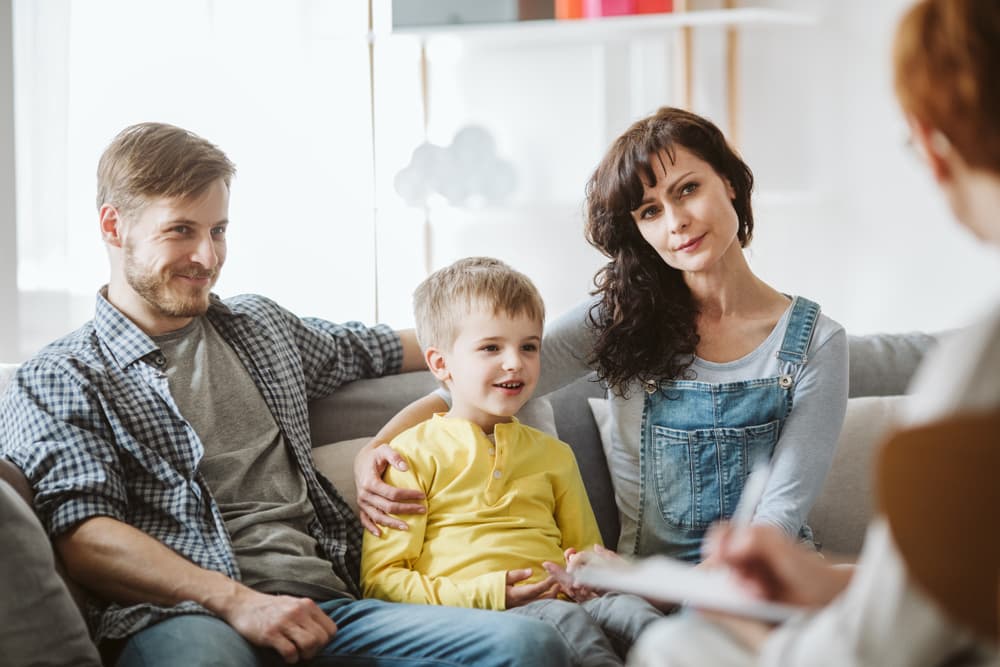 A marriage and family counselor works with a young family in a counseling session