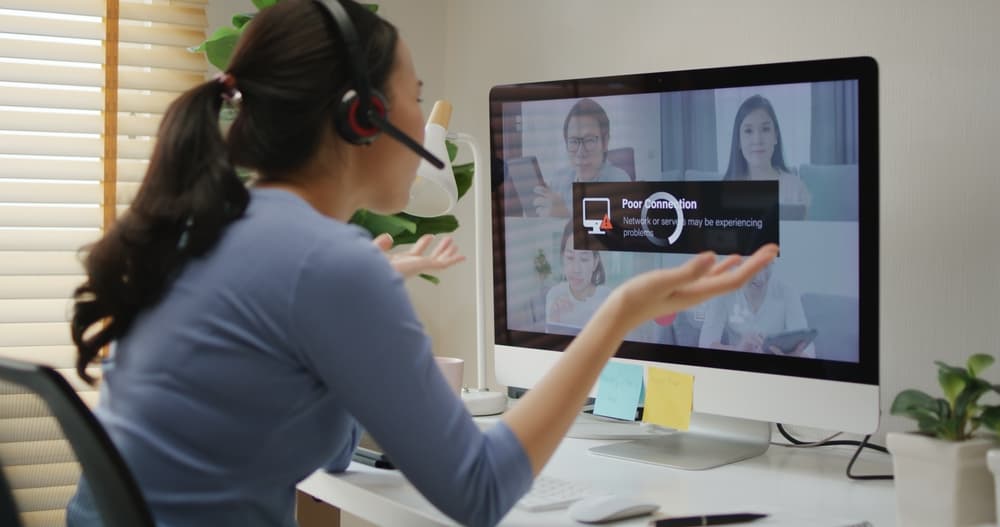 A manager leads a virtual meeting with her online team.