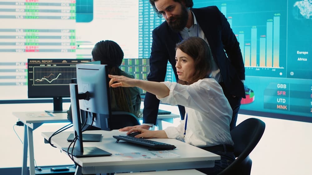 A businesswoman reviews project plans with her colleague.