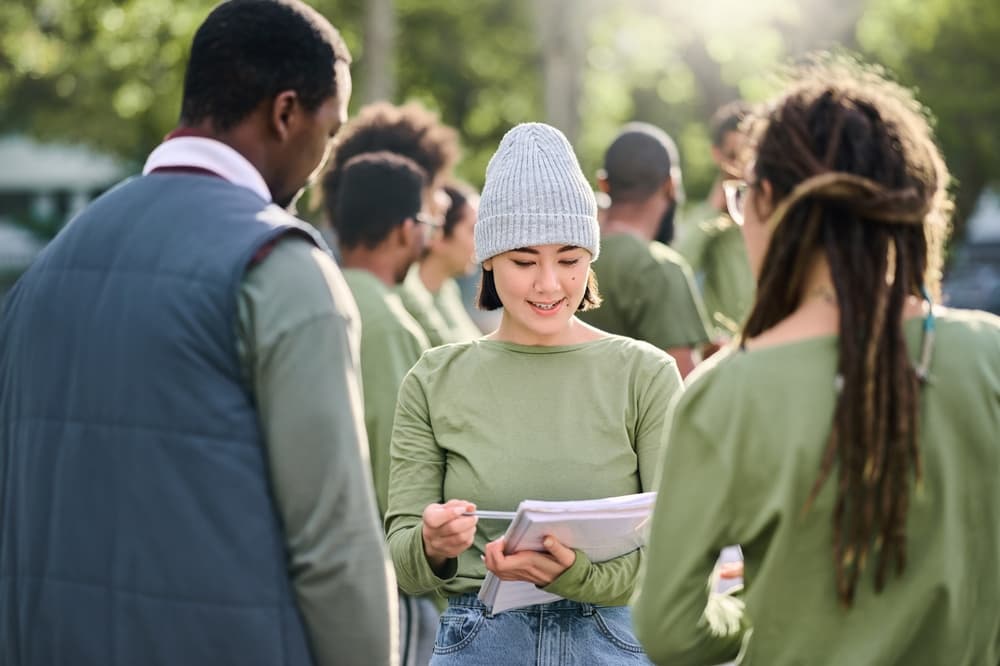 A community manager coordinates with her team for an outdoor event.