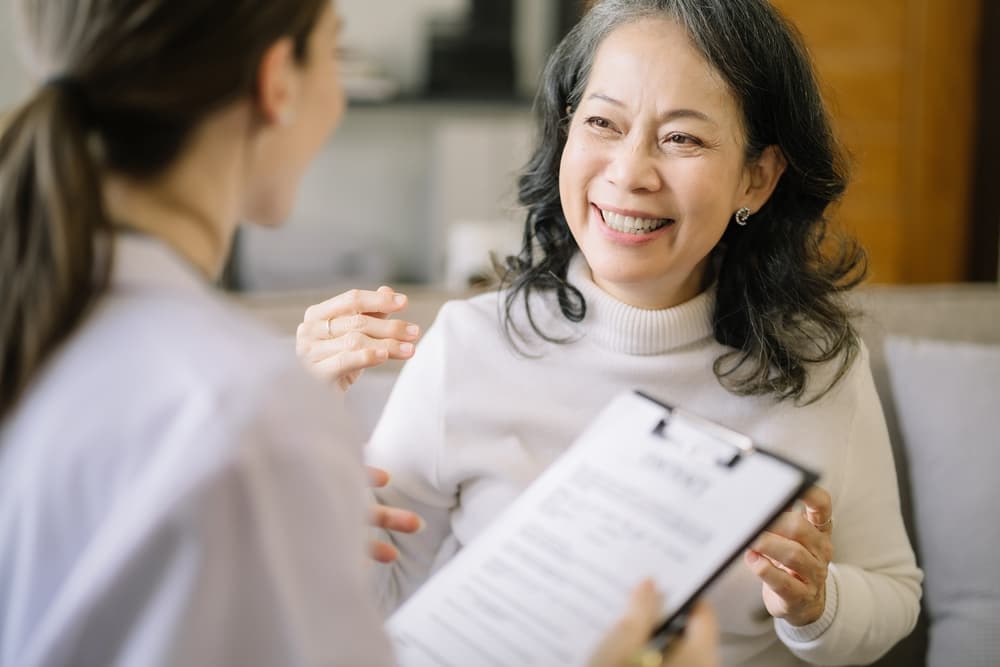 A smiling senior woman consults with a manager of a public health clinic.