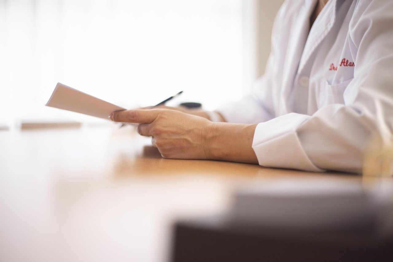 hospital administrator holding documents at a desk